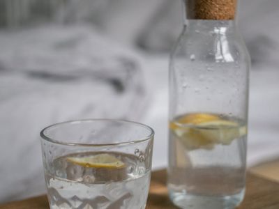 Glass bottle of water on a wooden surface nearby.